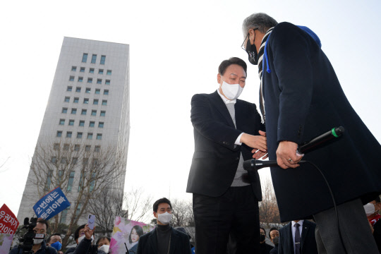 1일 국민의힘 윤석열 대선 후보가 서울 서초구 서울중앙지검 서문 앞에서 열린 '보수와 진보 진영통합 윤석열 후보 지지선언'에 참석하며 깨어있는시민연대당 이민구 대표와 악수하고 있다. 국회사진기자단=연합뉴스.